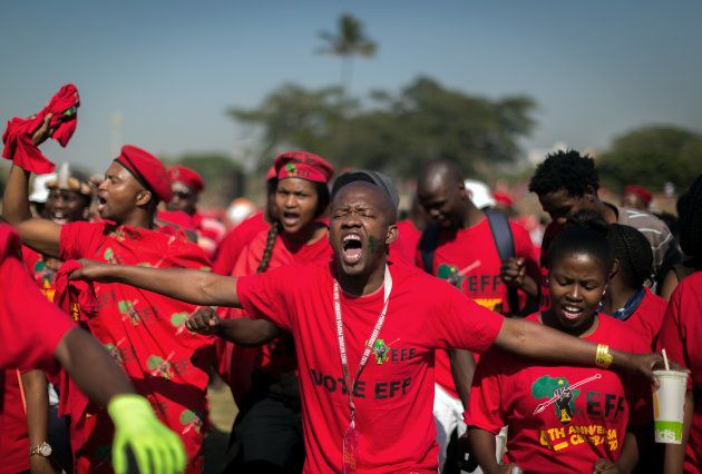 Supporters of South African radical-left opposition party Economic Freedom Fighters (EFF) gesture as they sing, cheer and dance during a mass rally marking the party's fourth anniversary on July 29, 2017 at the Curries Fountain Stadium in Durban. / AFP PHOTO / RAJESH JANTILAL (Photo credit should read RAJESH JANTILAL/AFP/Getty Images)