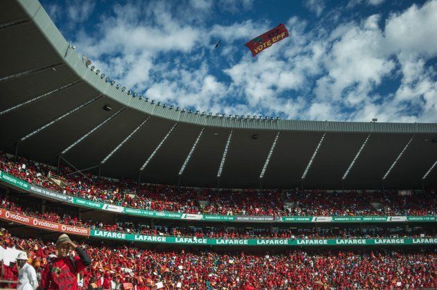 A plane drags a EFF sign above the South African opposition radical party Economic Freedom Fighters supporters attending the official local election manifesto launch at Soweto's Orlando Stadium in Johannesburg on April 30, 2016, targeting white privilege and the ruling African National Congress. Around 40,000 people turned Orlando stadium in Soweto into a sea of red as supporters roared their approval of fiery EFF leader Julius Malema's promises to seize white-owned land without compensation and nationalise the banks. / AFP / MUJAHID SAFODIEN (Photo credit should read MUJAHID SAFODIEN/AFP/Getty Images)