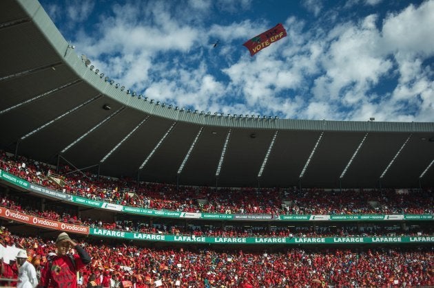 A plane drags a EFF sign above the South African opposition radical party Economic Freedom Fighters supporters attending the official local election manifesto launch at Soweto's Orlando Stadium in Johannesburg on April 30, 2016, targeting white privilege and the ruling African National Congress. Around 40,000 people turned Orlando stadium in Soweto into a sea of red as supporters roared their approval of fiery EFF leader Julius Malema's promises to seize white-owned land without compensation and nationalise the banks. / AFP / MUJAHID SAFODIEN (Photo credit should read MUJAHID SAFODIEN/AFP/Getty Images)