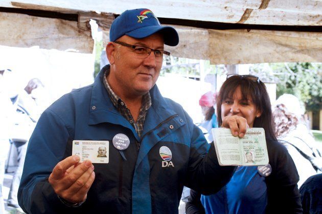 South African main opposition party Democratic Alliance Nelson Mandela Bay mayoral candidate Athol Trollip (C) shows his ID prior to vote in the municipal election at a polling station on August 3, 2016 in Port Elizabeth, South Africa. (Photo credit should read MICHAEL SHEEHAN/AFP/Getty Images)