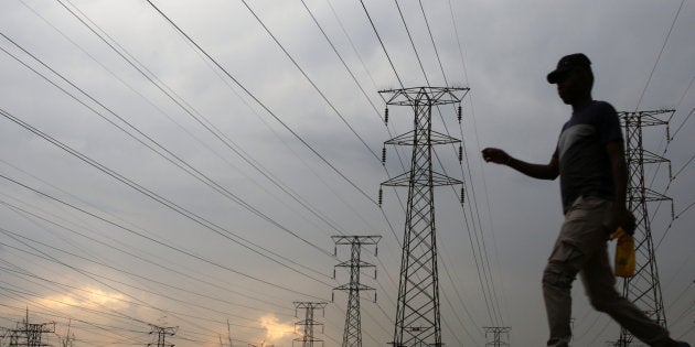 A man walks past electricity pylons in Soweto, South Africa, March 5, 2018.