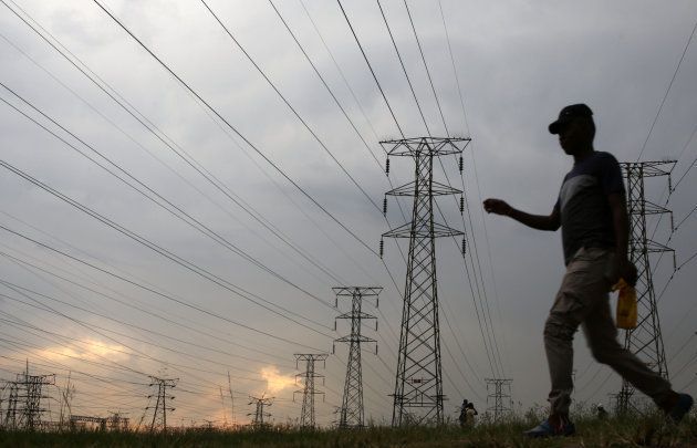 A man walks past electricity pylons in Soweto, South Africa, March 5, 2018. REUTERS/Siphiwe Sibeko