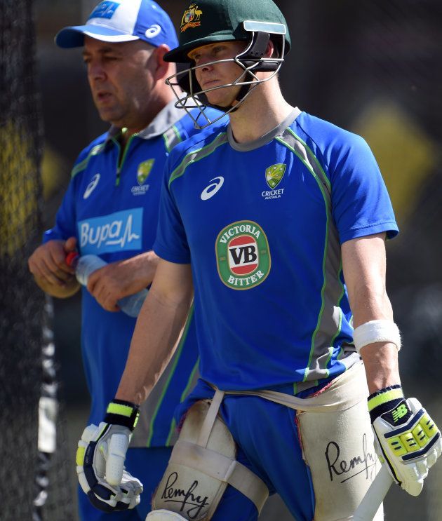 Australia's captain Steve Smith walks with head coach Darren Lehman (L) during a net practice session at the Gabba in Brisbane on December 14, 2016.