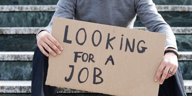 Young businessman holding sign Looking for a job