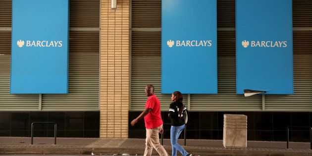 A couple walks past a Barclays logo in Johannesburg.