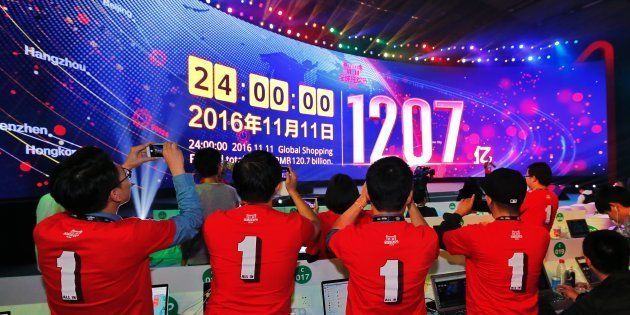 SHENZHEN, CHINA - NOVEMBER 12: Working staff of Alibaba Group take photos of a screen which indicates sales figure of Alibaba Group after the Singles' Day Global Shopping Festival at Shenzhen Universiade Sports Centre on November 12, 2016 in Shenzhen, Guangdong Province of China. The latest sales figure of Alibaba Group has hit about 120.7 billion yuan this year, which has set a new record compared with the previous data.