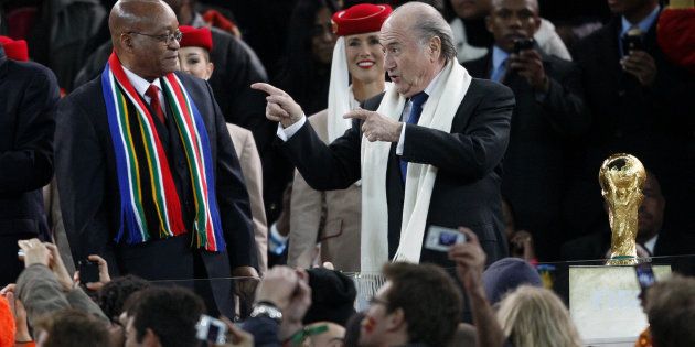 President Jacob Zuma (L) and former FIFA president Sepp Blatter (R) prepare to hand over the World Cup trophy to Spain.