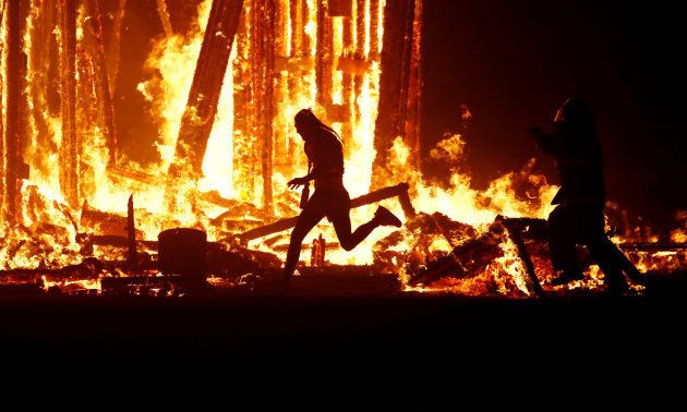 A Burning Man participant evades a chasing firefighter and runs into the flames of the "Man Burn" after evading the attempted tackles of multiple rangers and law enforcement personnel.