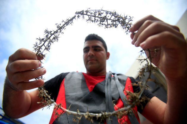 A Christian man carries a crown of thorns during a re-enactment of the crucifixion of Jesus Christ on Good Friday in al-Qraya village, \ southern Lebanon. April 14, 2017. REUTERS/Ali Hashisho