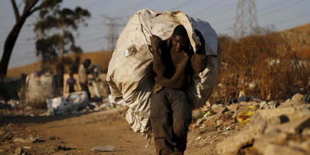 An unemployed man carries a bag full of recyclable waste material which he sells for a living, in Daveland near Soweto, South Africa August 4, 2015.