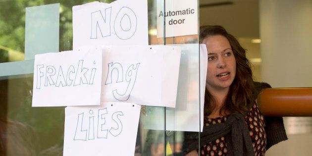 An anti-fracking demonstrator glues herself to the headquarters of Bell Pottinger, the PR firm used by Cuadrilla, in central London August 19, 2013.