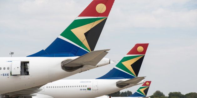 The logo of South African Airways sits on the tailfins of Airbus Group NV A340, left, and A330-200 aircraft parked at O.R. Tambo International airport in Johannesburg, South Africa.