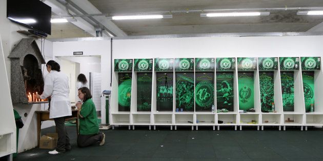 Employees of Chapecoense soccer team pray inside the team's locker room at the Arena Conda stadium in Chapeco, Brazil.