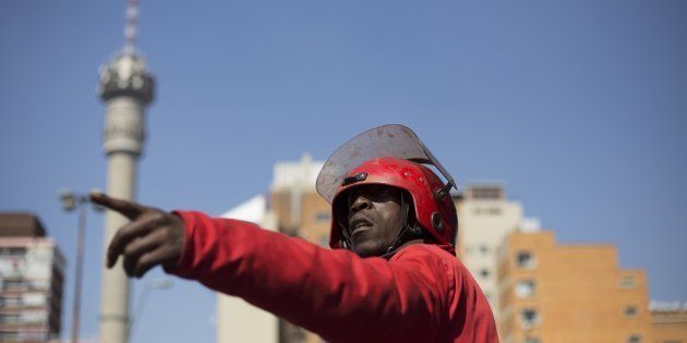 The Gauteng human settlements department has been stripped bare in a court spat with the Red Ants. Here, a member of the Red Ants directs subordinates as they hurl household items belonging to residents of the Williston Building onto the street in Hillbrow, Johannesburg, on 12 August 2015.