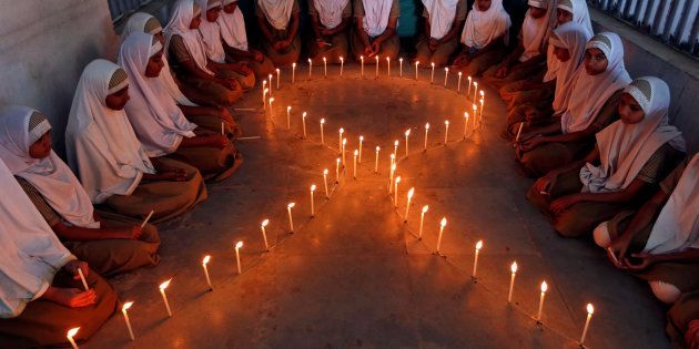 School girls light candles in the shape of a ribbon during a HIV/AIDS awareness campaign ahead of World Aids Day, in Ahmedabad, India November 30, 2016.