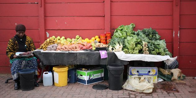 A street vendor waits for customers as she sits in front of her fruit-and-vegetables stall in Johannesburg, South Africa.
