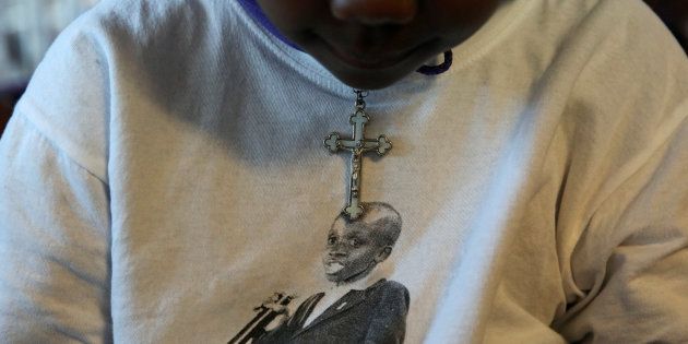 A child wears a cross over a top featuring the image of the late Nkosi Johnson, one of the youngest victims of the HIV epidemic and died in 2001 from the disease, during the launch of the 5-Day countdown ahead of the AIDS2016 International Conference, at the orphanage Nkosi's Haven, which was named after Johnson, in Johannesburg, South Africa July 13, 2016.