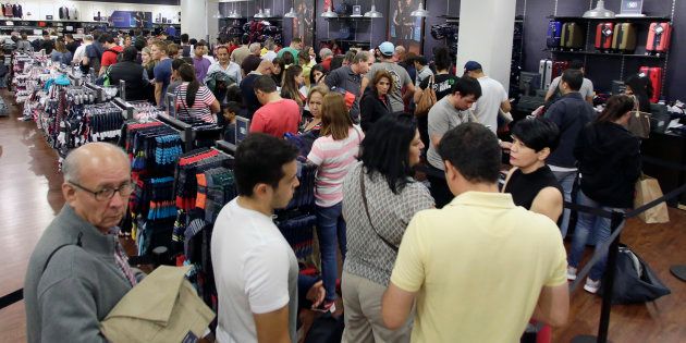 Shoppers stand in line to pay for their purchased merchandise at a Tommy Hilfiger store on Black Friday, Nov. 25, 2016, in Miami.