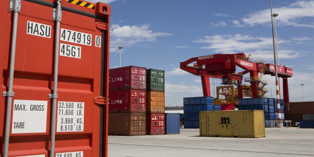 A loading crane sits near shipping containers on the opening day of Transnet SOC Ltd.'s new container handling terminal at City Deep inland port in Johannesburg, South Africa, on Thursday, Nov. 26, 2015. Transnet plans to spend as much as 380 billion rand over the next decade to expand and upgrade rail and port capacity in South Africa, the world's biggest manganese producer and the continents largest source of iron ore and coal. Photographer: Karel Prinsloo/Bloomberg via Getty Images