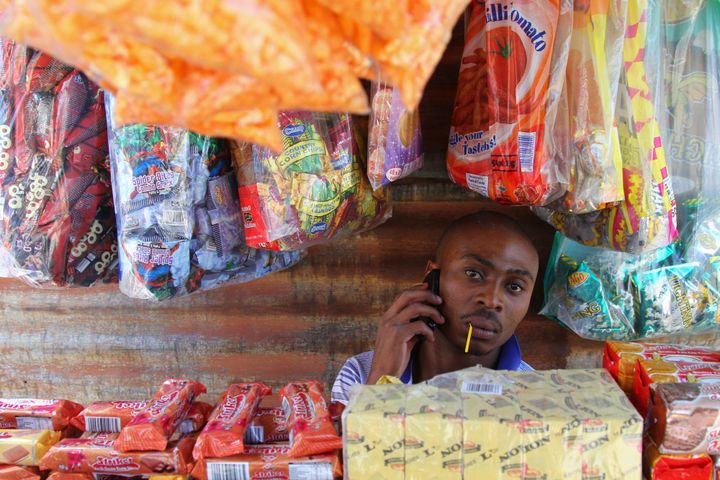 A street vendor who sells prepaid Vodacom airtime makes a call on his cellphone in Alexandra township in Johannesburg, South Africa, on Monday, January 28, 2013.