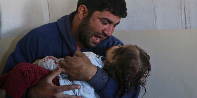 Iraqi Omar Ali grieves as he holds his dead daughter Amira, 15 months, who was killed by an Islamic state mortar shell in the Al-Tahrir neighborhood, at a field hospital set up by the Iraqi special forces medical unit, at the Al-Samah front line neighborhood, in Mosul, Iraq, Wednesday, Nov. 23, 2016.