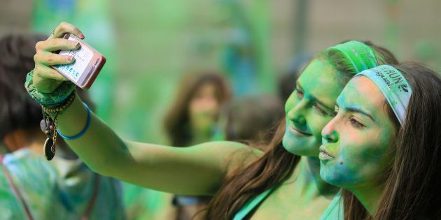 People covered with colorful Gulal powder during the Color Run, a race with party, music and colors in Barcelona city. Catalonia, Europe.