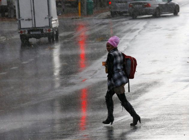 A woman runs from a rain as storms hit Cape Town, South Africa, June 7, 2017.