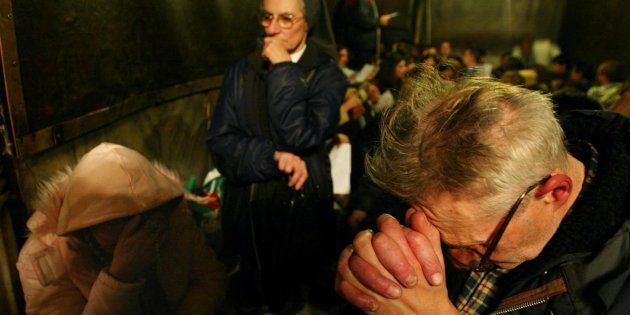 Catholic Christians pray on Christmas Eve along with other pilgrims inthe place where Christians believe Jesus was born, in a cave under theChurch of the Nativity in Bethlehem December 24, 2002.