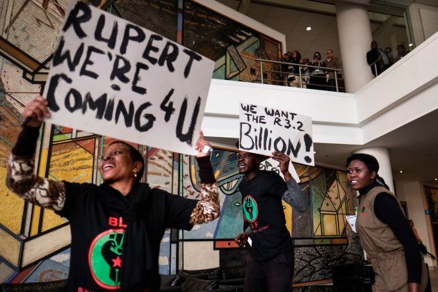 A placard with a slogan against Johann Rupert, the heir of South African business tycoon Anton Rupert, the chairman of the Swiss-based luxury-goods company Richemont as well as of the South Africa-based company Remgroins is displayed as members of the Black First Land First (BLF) movement demonstrate inside an Absa Bank branch in Johannesburg on June 28, 2017.