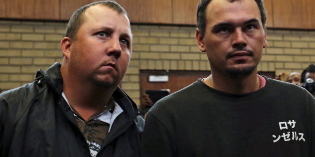 Theo Martins and Willem Oosthuizen (R) appear in court after an online video emerged showing them pushing Victor Mlotshwa into a coffin and threatening to burn him alive, at the Middleburg magistrates High Court, in Mpumalanga.