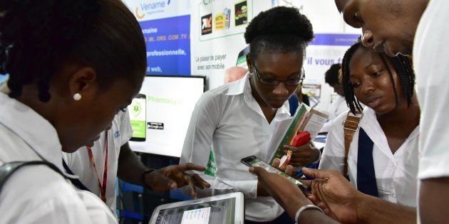Visitors look at tablets and smartphones on the first day of the 2016 Africa Web Festival (AWF) in Abidjan on November 29, 2016.