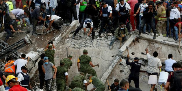 Soldiers, rescuers and people work at a collapsed building after an earthquake in Mexico City, Mexico September 19, 2017.
