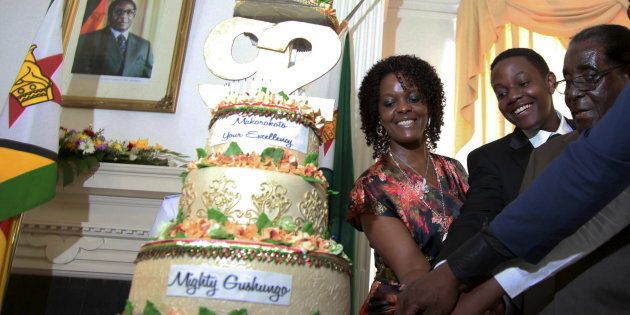 Zimbabwean President Robert Mugabe (R) is helped by his wife Grace (L) and son Chatunga (C) to cut a cake to celebrate his 92nd birthday at State House in Harare, February 22, 2016. Mugabe turned 92 on Sunday. REUTERS/Philimon Bulawayo