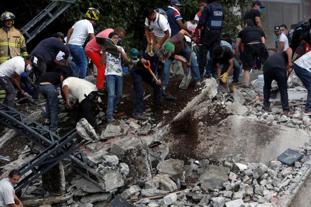 People remove debris of a collapsed building after an earthquake hit Mexico City, Mexico September 19, 2017. Picture taken September 19, 2017. REUTERS/Ginnette Riquelme