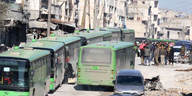 People get on buses to be evacuated from al-Sukkari rebel-held sector of eastern Aleppo, Syria on 15 December 2016.