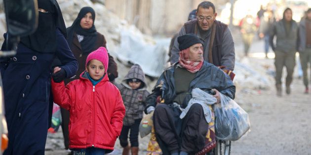 People walk as they gather to be evacuated from a rebel-held sector of eastern Aleppo, Syria December 15, 2016.