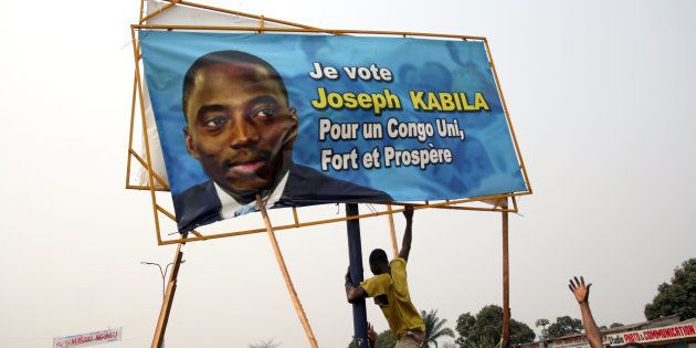 A Congolese protester tears down a campaign poster of President Joseph Kabila in Kinshasa, capital of the Democratic Republic of Congo, July 25, 2006.
