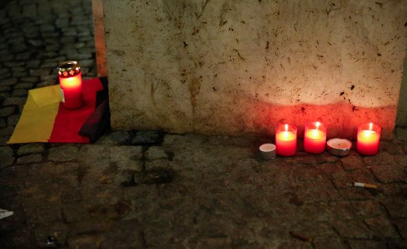 A candle is burning on a German national flag near the site where a truck ploughed through a crowd at a Berlin Christmas market on Breitscheidplatz square near the fashionable Kurfuerstendamm avenue in the west of Berlin, Germany, December 20, 2016 REUTERS/Fabrizio Bensch