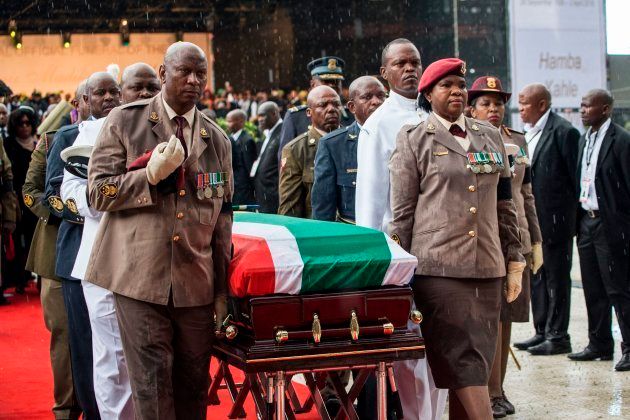 Members of the South African military carry the coffin of anti-Apartheid icon Winnie Madikizela Mandela during her funeral at the Orlando Stadium, in the township of Soweto, concluding 10 days of national mourning on April 14, 2018, in Johannesburg. South Africans turned out in their thousands to bid final goodbyes to the anti-apartheid icon and Nelson Mandela's former wife who was laid to rest with full state honours. Winnie Mandela, who died in Johannesburg aged 81 on April 2 after a long illness, has been celebrated for helping keep Nelson Mandela's dream of a non-racial South Africa alive while he was behind bars for 27 years. / AFP PHOTO / WIKUS DE WET (Photo credit should read WIKUS DE WET/AFP/Getty Images)