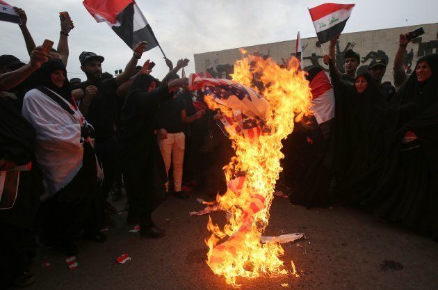 Iraqi protestors burn a US flag during a demonstration in Baghdad on April 15, 2018, opposing the joint Western air strikes against Syria's regime.