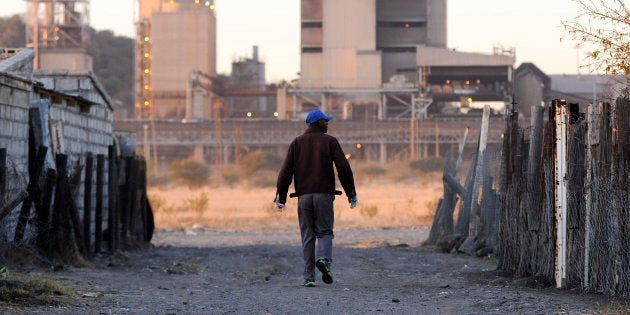 A township resident walks past Lonmin's Marikana platinum mine.