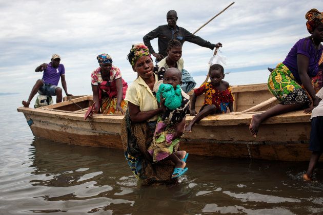 Refugees from Tchomia in the Democratic Republic of Congo arrive on boat at the Nsonga landing site on April 9, 2018 in Nsonga, Uganda.