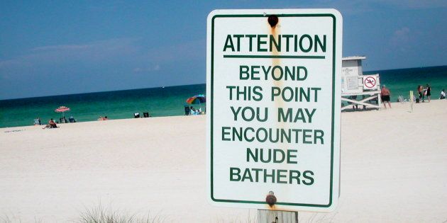 Signage warning beach visitors of nude bathers.