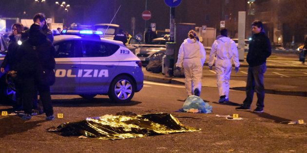 A body is covered with a thermic blanket after a shootout between police and a man near a train station in Milan's Sesto San Giovanni neighborhood, Italy, early Friday, Dec. 23, 2016. Italy's interior minister Marco Minniti says the man killed in an early-hours shootout in Milan is