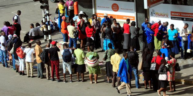 People queue to withdraw cash from a local bank in central Harare, Zimbabwe. REUTERS/Philimon Bulawayo