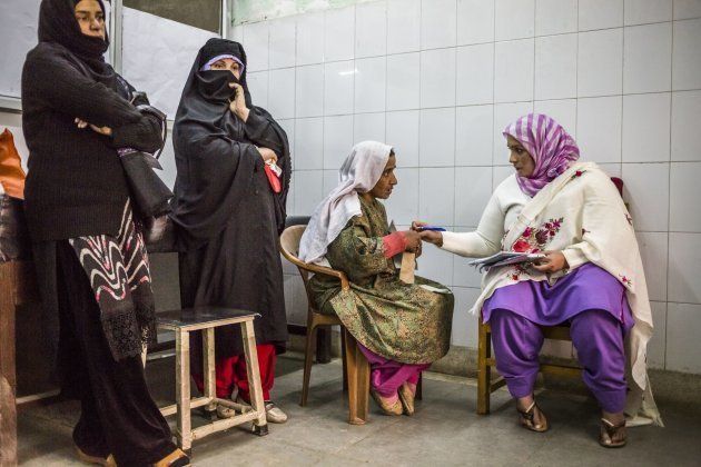 A Kashmiri patient speaks with a member of medical staff as she waits to be seen during a trauma and depression out-patient clinic, held by Dr Arshad Hussain.