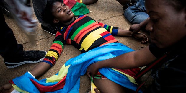 A Congolese protester lies on the ground after police opened fire wth rubber bullets whilst they protest outside the Democratic Republic of the Congo's Embassy in defiance of their President, Joseph Kabila on December 20, 2016 in Pretoria.