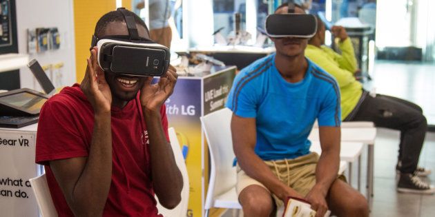 Customers try out Samsung Electronics Co. Gear VR Oculus Virtual Reality headsets inside an MTN Group Ltd. phone store in Cape Town, South Africa, on Wednesday, Dec. 21, 2016. South Africa was a bright spot for banks on the continent in 2016, with stocks shrugging off the nation's economic woes to head for the third-best performance in the past decade. Photographer: Dean Hutton/Bloomberg via Getty Images