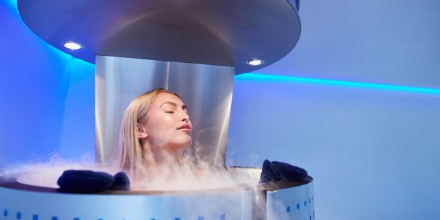 Portrait of young woman in a whole body cryo sauna. Female getting cryo therapy at the cosmetology clinic.