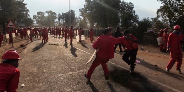 Members of the 'Red Ant Security Relocation and Eviction Services' watch our for stones thrown by protestors from Sicelo settlement in Meyerton, south of Johannesburg.